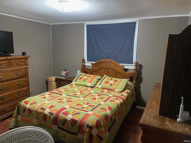 bedroom featuring dark hardwood / wood-style floors, crown molding, and wood walls