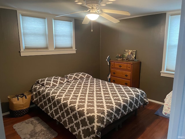 bedroom with dark hardwood / wood-style floors, ceiling fan, and crown molding