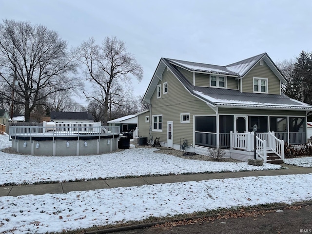 snow covered rear of property with central air condition unit