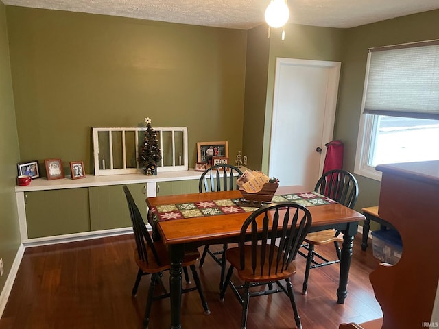 dining space with a textured ceiling and hardwood / wood-style flooring