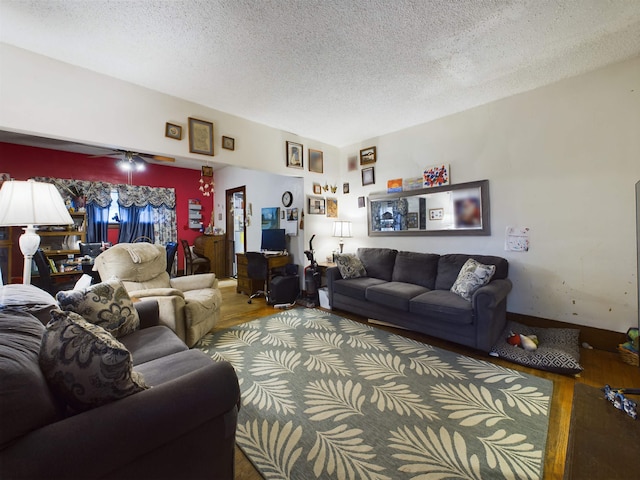 living room featuring wood-type flooring, a textured ceiling, and ceiling fan