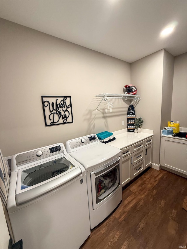 laundry area featuring cabinets, washer and clothes dryer, and dark wood-type flooring