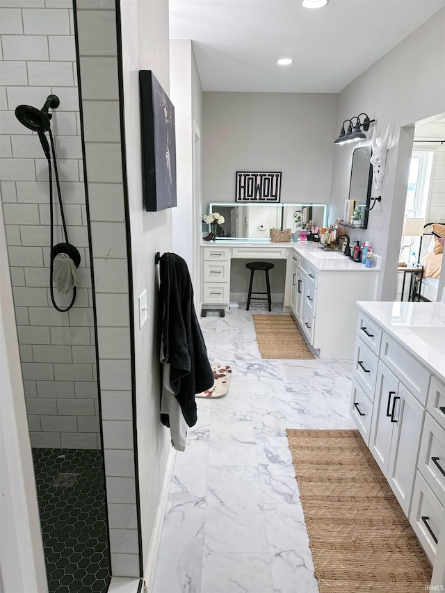 bathroom featuring a tile shower and vanity