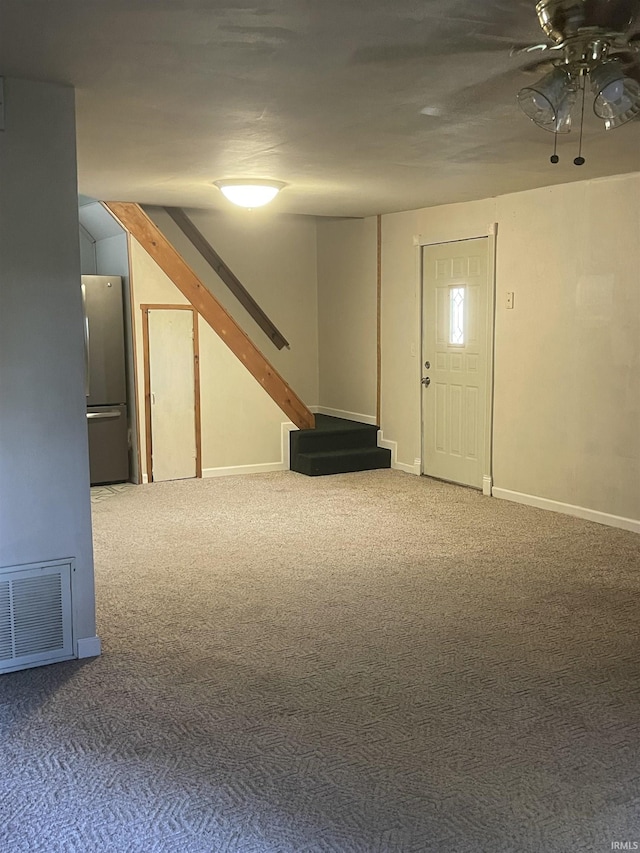 basement featuring carpet flooring and stainless steel fridge