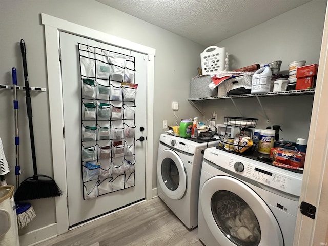 washroom featuring washer and clothes dryer, a textured ceiling, and light wood-type flooring