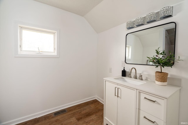 bathroom featuring vanity, wood-type flooring, and vaulted ceiling