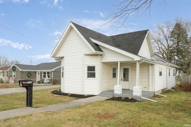 view of front of home with covered porch and a front lawn