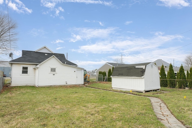 rear view of house featuring a storage shed and a yard