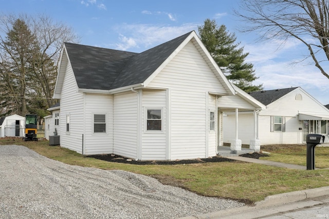 view of side of property featuring central air condition unit and a lawn