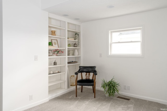 sitting room featuring carpet flooring and built in features