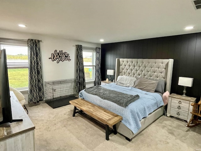 bedroom featuring wooden walls and light carpet