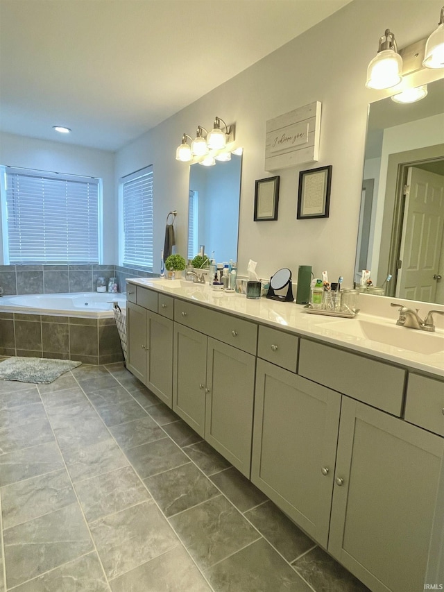 bathroom with tile patterned flooring, vanity, and tiled tub