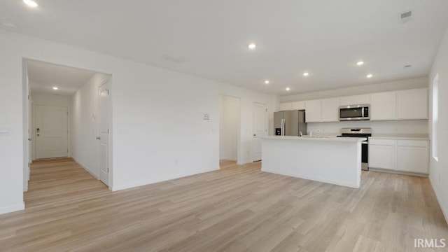 kitchen with white cabinetry, a kitchen island with sink, light hardwood / wood-style flooring, and stainless steel appliances