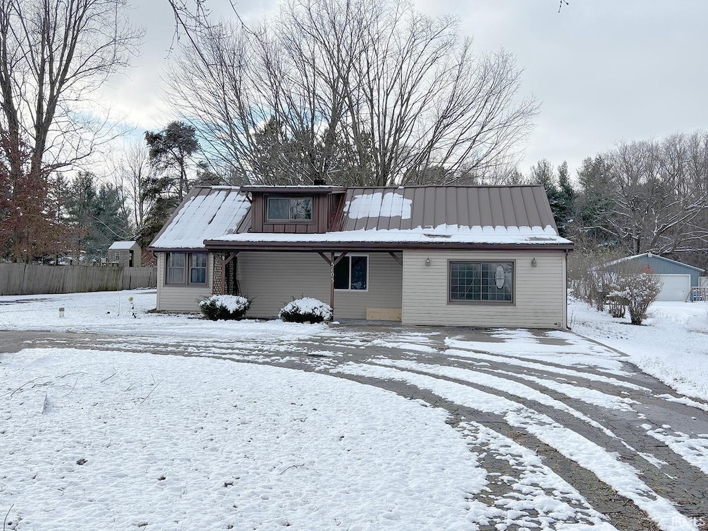 snow covered property featuring an outbuilding and a garage