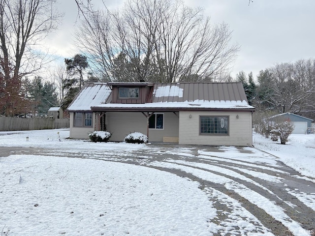 snow covered property featuring an outbuilding and a garage