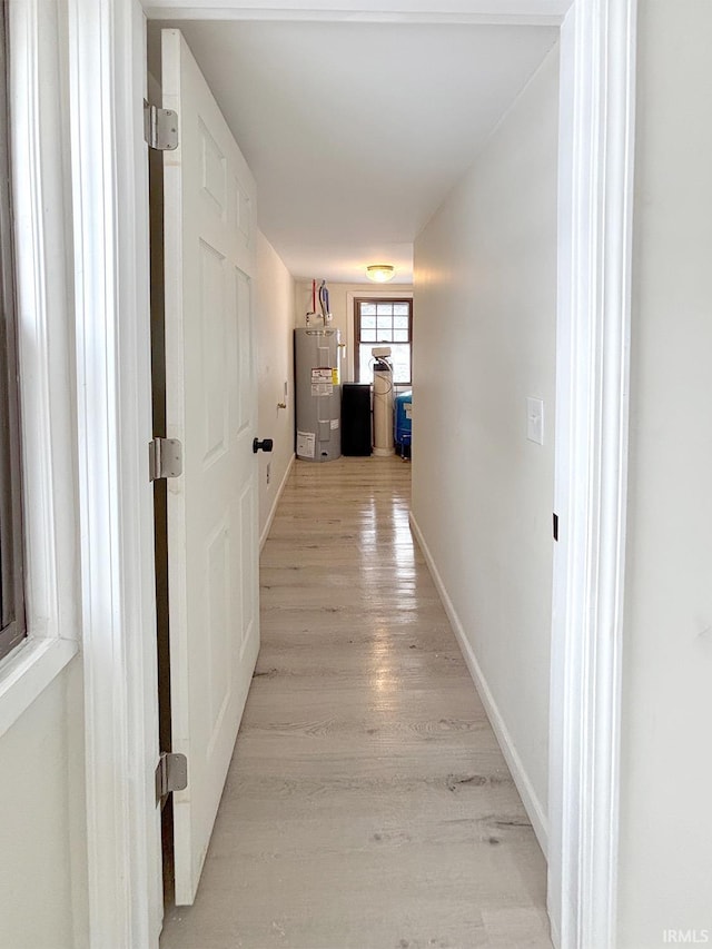 hallway with electric water heater and light wood-type flooring