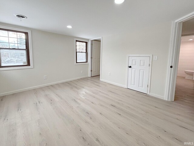 empty room with light wood-type flooring and a wealth of natural light