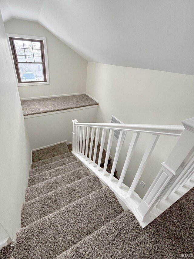 stairs featuring carpet flooring and lofted ceiling