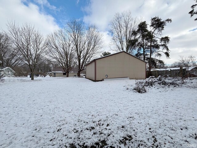 yard covered in snow with an outbuilding