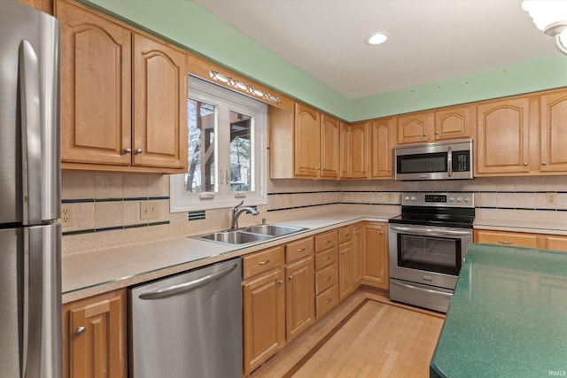 kitchen featuring light hardwood / wood-style floors, sink, appliances with stainless steel finishes, and tasteful backsplash