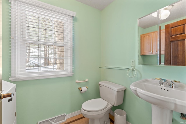 bathroom featuring sink, hardwood / wood-style floors, and toilet