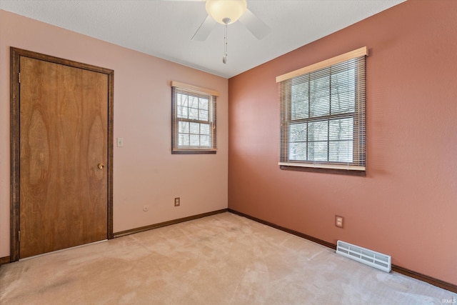 carpeted spare room with ceiling fan