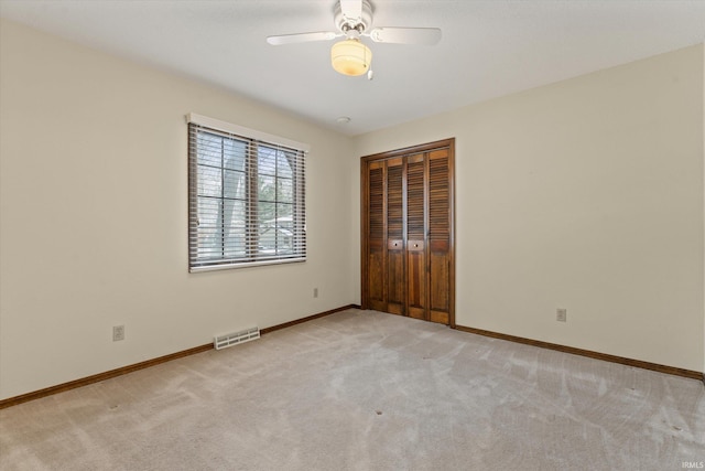 carpeted spare room featuring ceiling fan