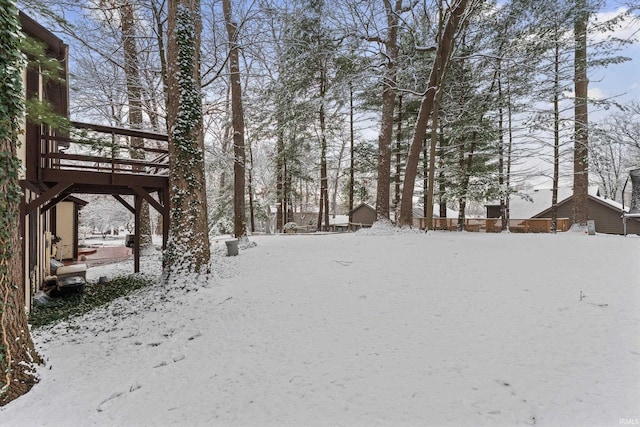 yard layered in snow featuring a wooden deck