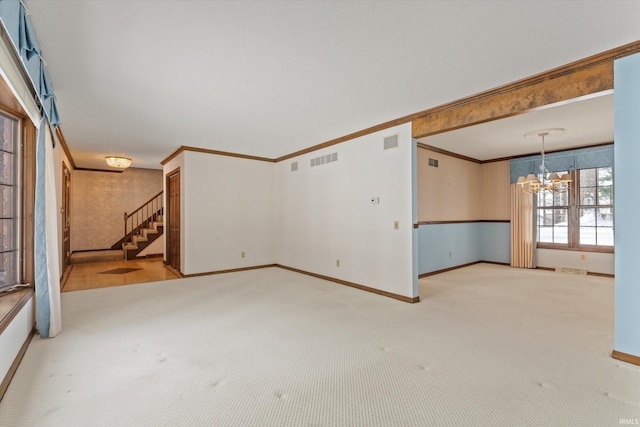 unfurnished living room with light colored carpet, crown molding, and an inviting chandelier