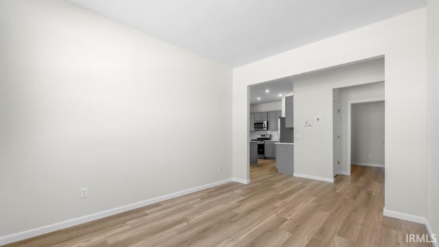 unfurnished living room with light wood finished floors and baseboards