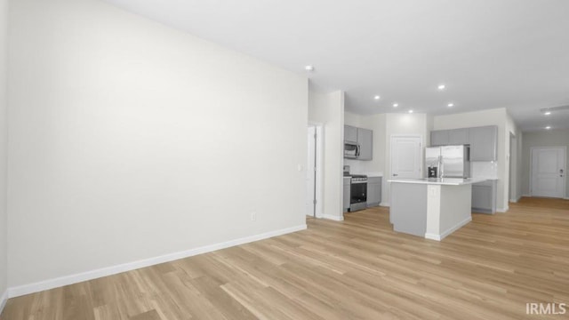 unfurnished living room featuring baseboards, recessed lighting, and light wood-style floors