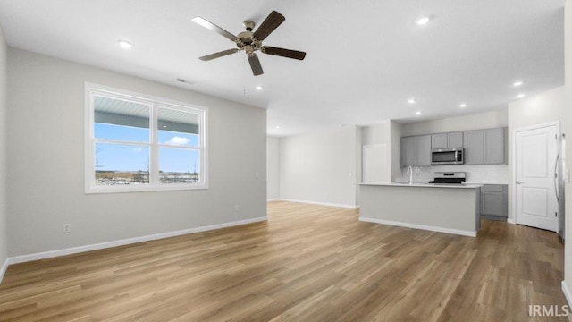 unfurnished living room featuring light wood-style flooring, visible vents, baseboards, and recessed lighting