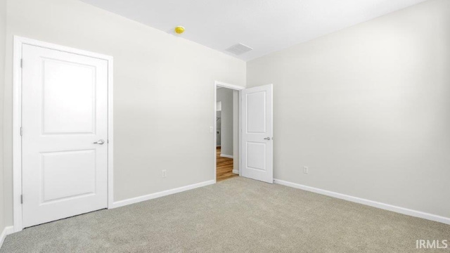 unfurnished bedroom with light colored carpet, visible vents, and baseboards