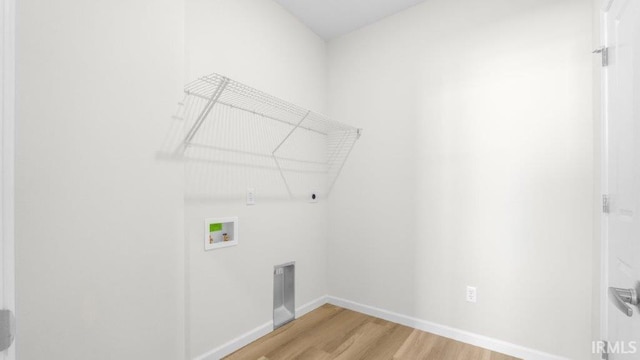 laundry room with hookup for a washing machine, hookup for an electric dryer, wood finished floors, laundry area, and baseboards