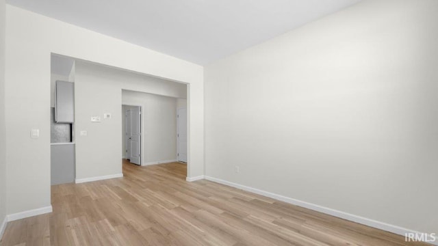 unfurnished room featuring light wood finished floors and baseboards