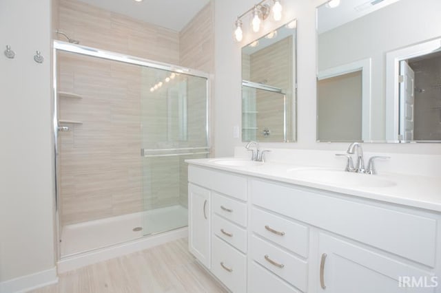 bathroom with a shower with door and vanity