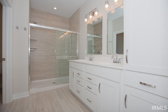 bathroom featuring hardwood / wood-style floors, vanity, and walk in shower