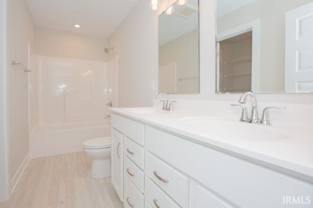 full bathroom with vanity,  shower combination, hardwood / wood-style flooring, and toilet