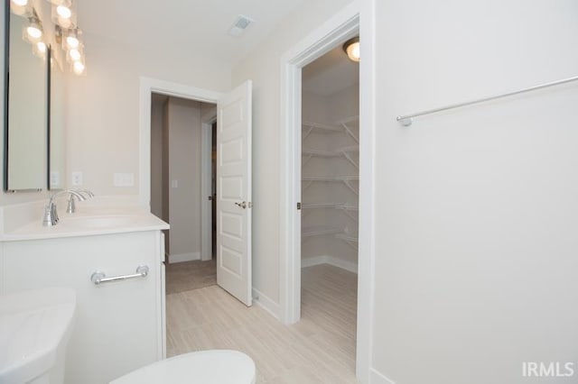 bathroom featuring hardwood / wood-style floors, vanity, and toilet