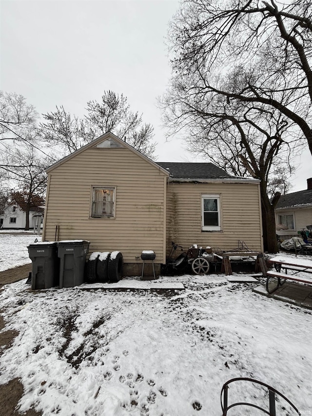 view of snow covered rear of property