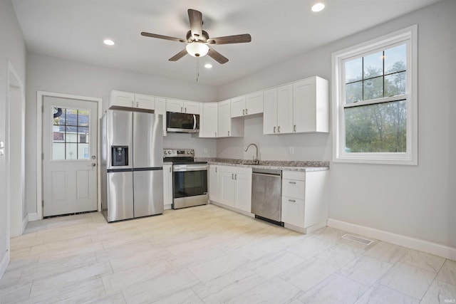 kitchen with ceiling fan, white cabinets, a healthy amount of sunlight, and appliances with stainless steel finishes