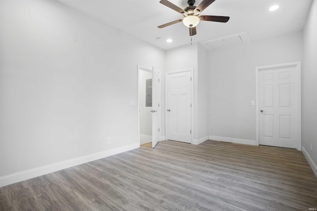 spare room featuring electric panel, hardwood / wood-style flooring, and ceiling fan