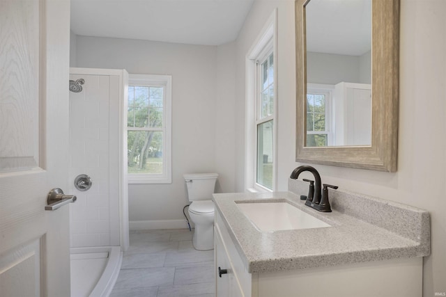 bathroom with plenty of natural light, toilet, a shower, and vanity