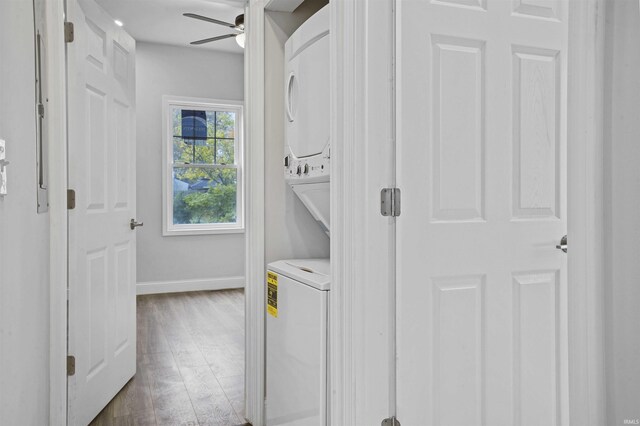 laundry room featuring dark hardwood / wood-style flooring, ceiling fan, and stacked washer and dryer