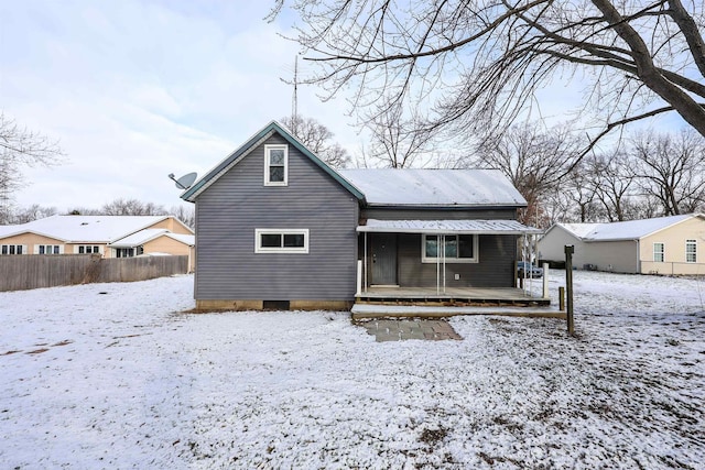 view of snow covered back of property