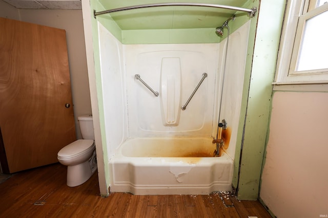 bathroom featuring hardwood / wood-style floors, toilet, and tub / shower combination