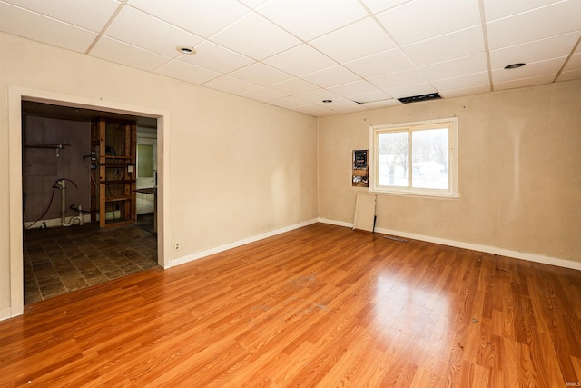 unfurnished room featuring a paneled ceiling and hardwood / wood-style flooring