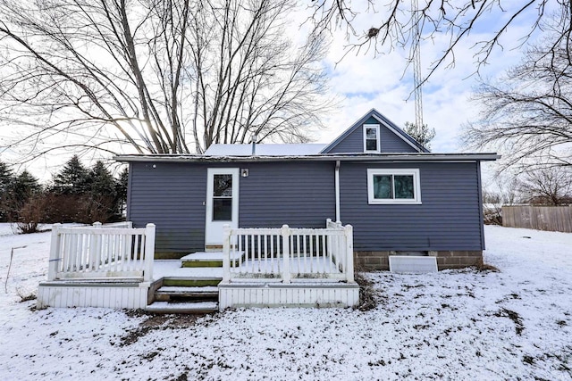 snow covered property with a deck