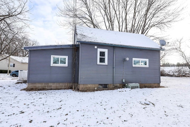 snow covered back of property with central air condition unit