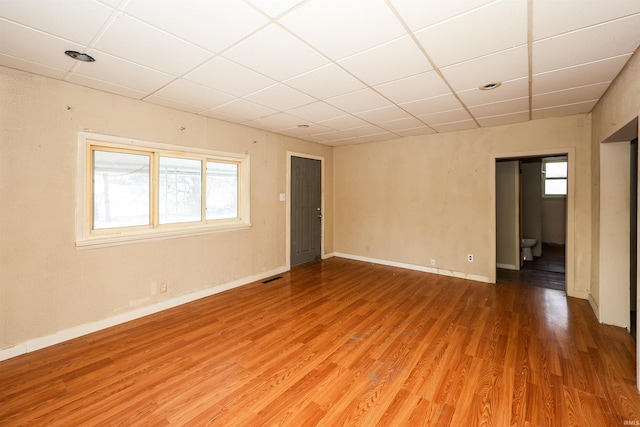 unfurnished room featuring a drop ceiling and wood-type flooring